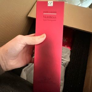 Box of beauty items including Estée Lauder